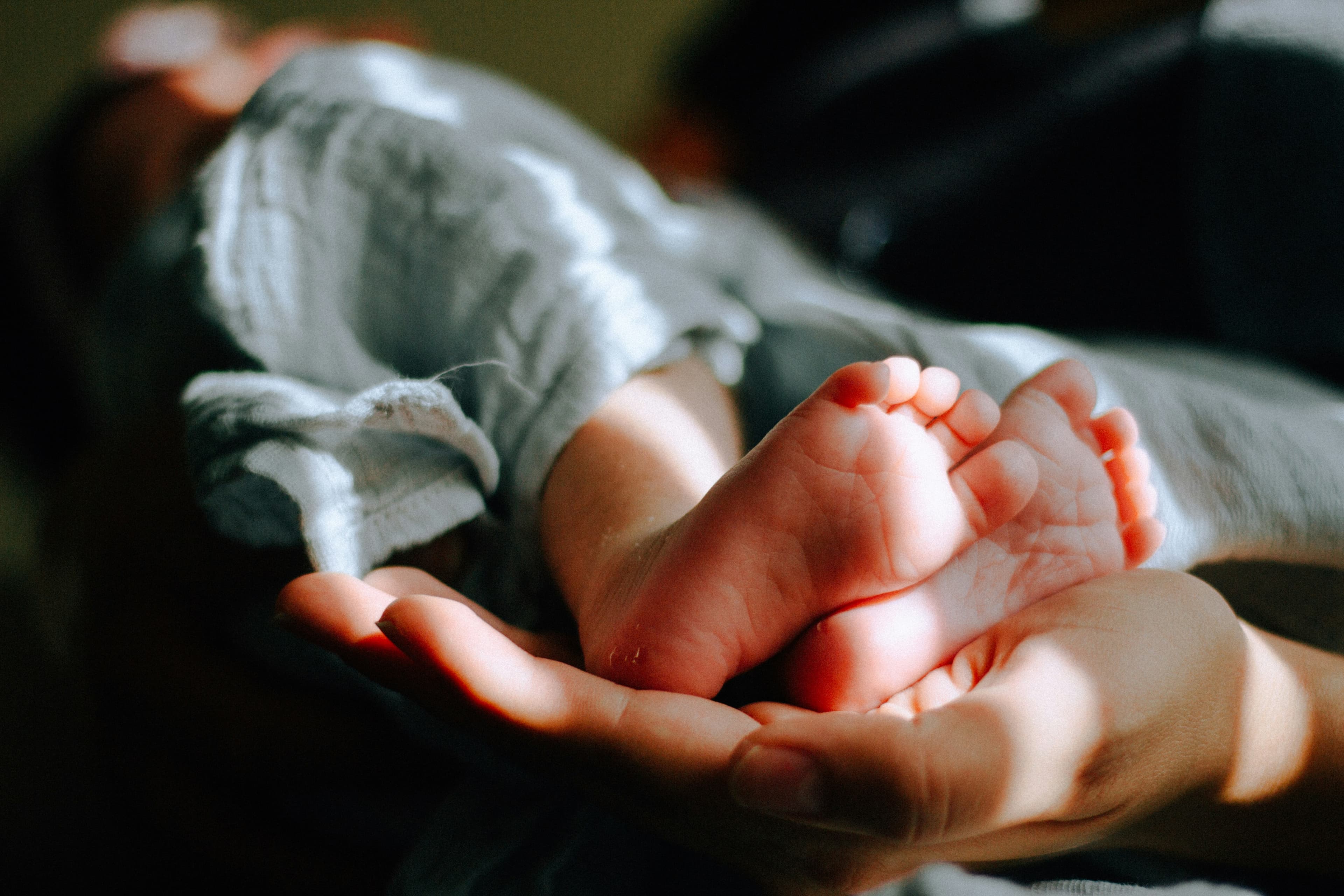 Mother gently holding her newborn's tiny feet